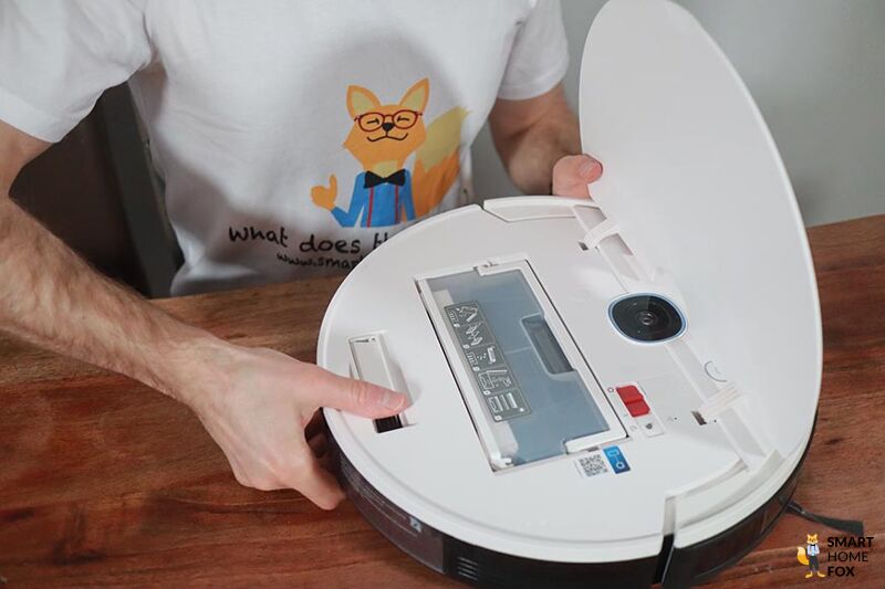 Der Yeedi Vac Max steht mit offener Klappe auf dem Tisch